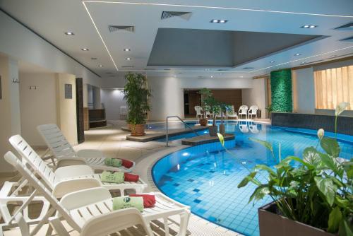 赫维兹哈维兹宫殿酒店的一个带椅子的大型游泳池和一个游泳池