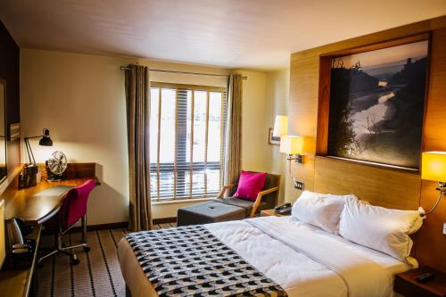 布里斯托布里斯托尔酒店的配有一张床、一张书桌和一扇窗户的酒店客房