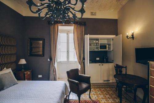森格莱阿森格莱阿萨利港酒店的一间卧室配有一张床、一张桌子和一个吊灯。