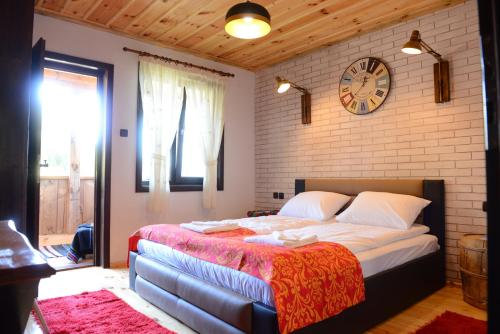 莱什顿Dream house的卧室配有一张大床,墙上挂着时钟