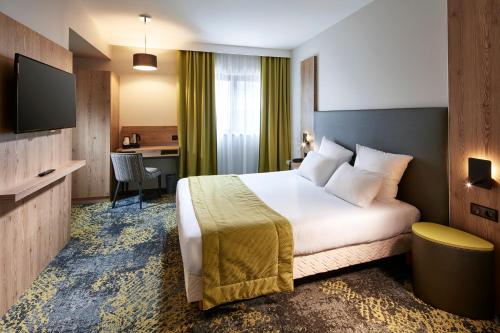 科尔马杜尔那酒店的配有一张床和一张书桌的酒店客房