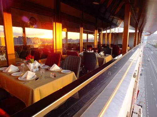 开塞利里佛斯酒店的餐厅设有桌椅,享有阳光