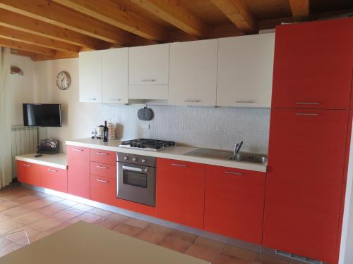 特雷莫西内Maisonette Caterina的红色的厨房,配有白色的橱柜和水槽
