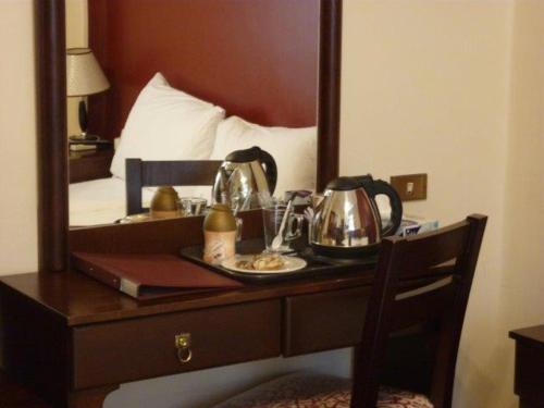 阿斯旺阿斯旺菲莱酒店的一张桌子,上面有两个茶壶和镜子