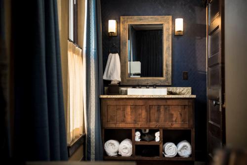 PawhuskaFrontier Hotel Pawhuska的浴室配有盥洗盆、镜子和毛巾