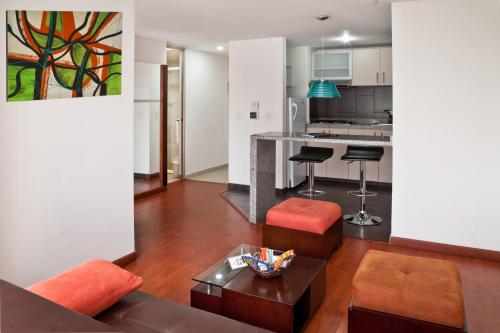 波哥大Aparta-Suites Mirador del Recuerdo的客厅配有沙发和桌子