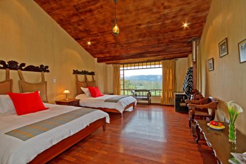 Hacienda La Alegría阿里希亚庄园酒店的一间卧室设有两张床和大窗户