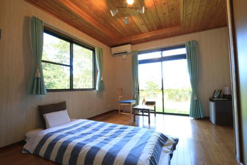 屋久岛尼克伊奇民宿的一间卧室配有一张带蓝色和白色棉被的床
