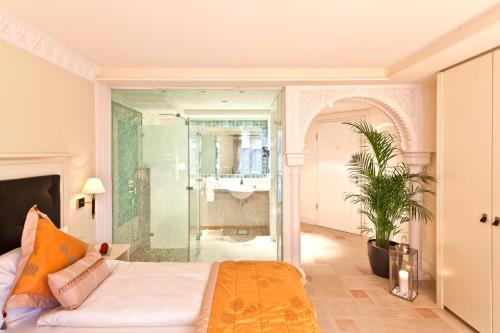 蒂宾根Boutiquehotel La Casa的一间卧室设有一张床和一个玻璃淋浴间