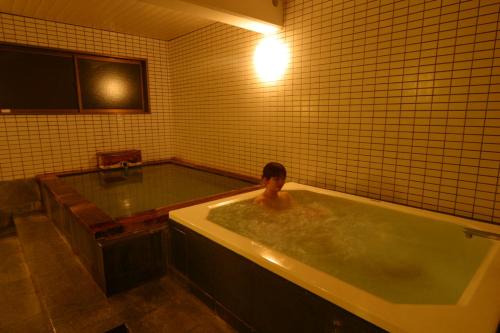 草津葡萄干旅馆的浴缸里的人
