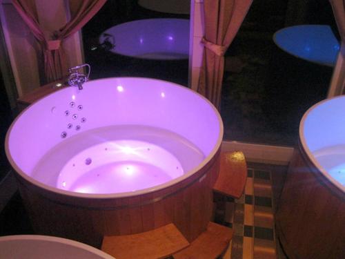 肯琴月亮山庄酒店的浴室配有大型木制浴缸及卫生间