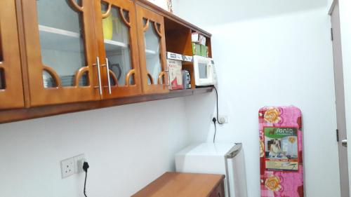 拉维尼亚山Sudarshi's Home的厨房配有木制橱柜和冰箱。