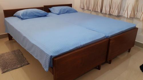 拉维尼亚山Sudarshi's Home的一张带蓝色床单和蓝色枕头的床