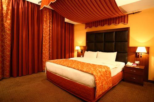 贝鲁特玛尔卡奇亚梦露套房公寓式酒店的一间卧室配有一张带红色窗帘的大床