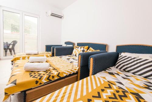 布德瓦Apartman Budva的配有黄色和黑色棉被的客房内的三张床