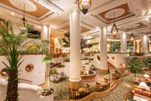 曼谷Montien Riverside Hotel Bangkok的拥有柱子和植物的酒店大厅