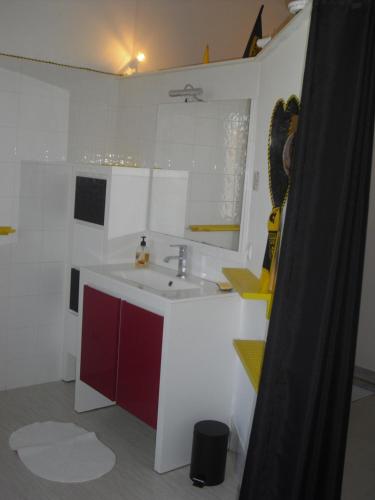 VixLes jardins de VIX的一间带水槽和红色及白色橱柜的浴室
