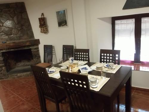 巴尔韦尔德德洛萨罗约斯Casa Rural Los Robles的用餐室配有桌椅和壁炉
