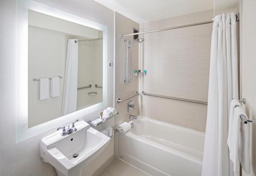格林维尔格林维尔凯悦酒店 的白色的浴室设有水槽和浴缸。