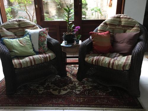 乌巴图巴普利马尔宾馆的客厅配有2把带枕头的藤椅