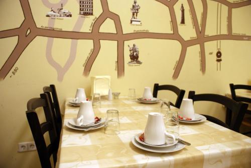 萨勒河畔哈雷5号旅馆的桌椅和长桌,带盘子和餐巾