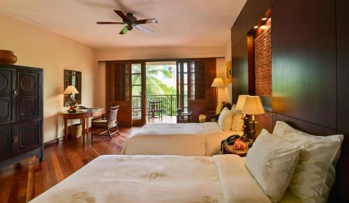 岘港岘港富丽华大酒店 的酒店客房设有两张床和一张桌子。