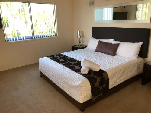 赫维湾赫维湾田庄度假村的一间卧室设有一张大床和大窗户