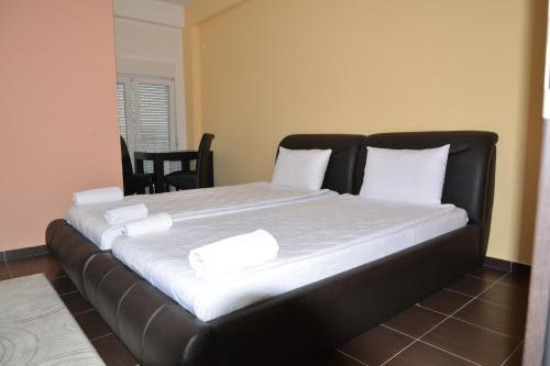 普里什蒂纳Hotel Konstantin的一张配有白色床单和白色枕头的大床