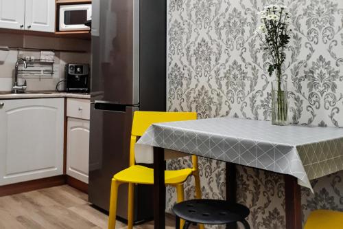 敖德萨Apartment - Heart of Odessa的厨房配有桌子和2把黄色椅子