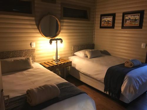马里兰Timmerstuga的一间卧室配有两张带镜子和灯的床