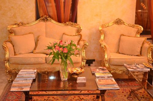 第聂伯罗Optima Collection Dnipro的客厅配有两把椅子和一张鲜花桌