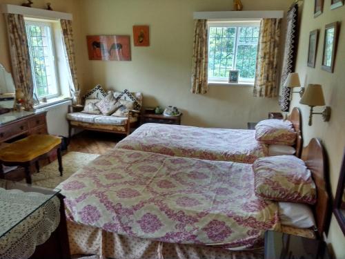 赫克瑟姆Thornley House的一间卧室配有一张床、一张沙发和两个窗户。