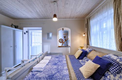 保拉德Ribizli Vintage Vendégház的一间卧室配有一张带蓝色和白色棉被的床