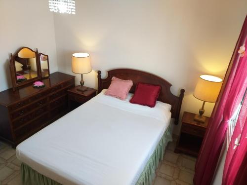 帕福斯777 Beach Guesthouse的一间卧室配有一张带2个床头柜和2盏灯的床。