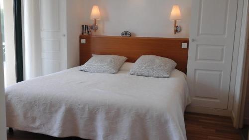 Saint-André-des-EauxSaint Denac - Golf de la Baule的卧室配有白色的床和2个枕头