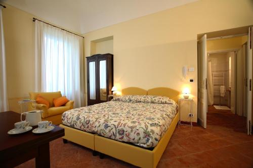 阿比亚诺德伊夫雷亚达兹格里奥别墅酒店的配有一张床和一把椅子的酒店客房