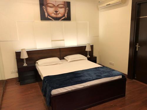 古尔冈Beautiful Apartments at Tarudhan Valley Golf Resort, Manesar的一间卧室配有一张大床和床头板