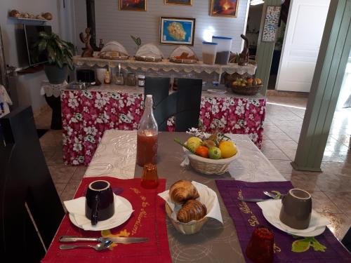 卡夫尔高原Les GREVILLEAS的一张桌子,上面放着一盘食物和一碗水果