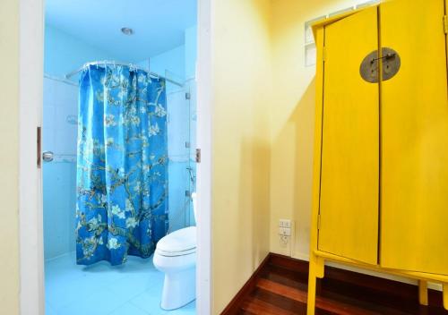 曼谷阿依度假屋的浴室设有卫生间和黄色的淋浴帘