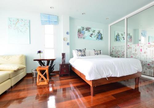 曼谷阿依度假屋的一间卧室配有一张床和一张沙发