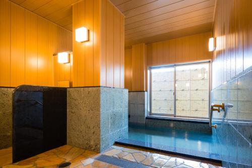 气仙沼市Japanese Style Hotel Isomura的一间带游泳池和窗户的浴室