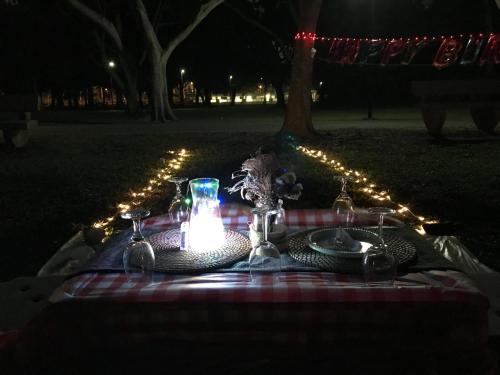 新加坡Glamping Kaki - Medium Bell Tent的一张带蜡烛、盘子和灯的野餐桌