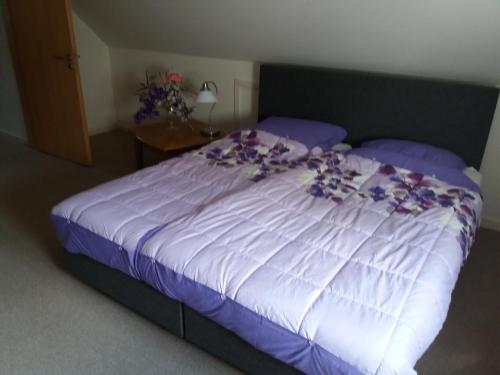 波卢巴库苏斯Casa Martin的卧室里一张布满紫色花的床铺