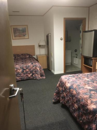 EstevanWinkys Motel的酒店客房设有两张床和一台平面电视。