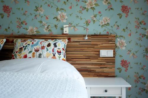 乌得勒支B&B Muntzicht的卧室配有白色床和花卉壁纸