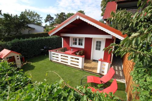 普劳西Blockbohlenhaus Plau am See的院子里的红色房子,带红色椅子
