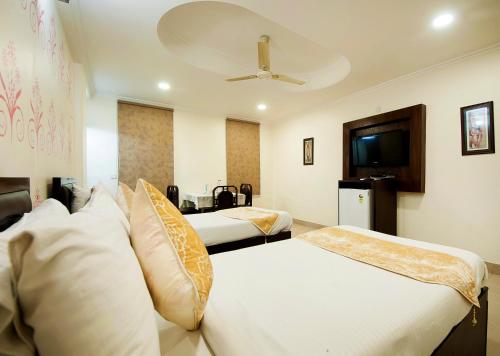 新德里HOTEL DAKHA INTERNATIONAL - Karol Bagh, New Delhi的一间酒店客房,设有两张床和电视
