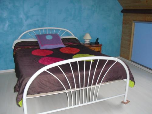 RéthôvilleVacances à Réthoville的卧室内的一张白色床,上面有紫色的书