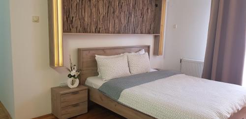 尼什Nice apartment的一间卧室配有一张带木制床头板的床