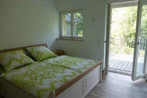 罗埃特根Ferienwohnung am Grölisbach的一间卧室设有一张床和一个滑动玻璃门